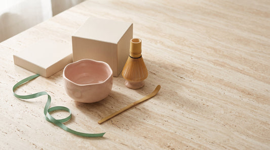 Coffret matcha offert en cadeau d'anniversaire : bol en céramique rose, chasen en bambou et support posés sur pierre travertin — Aoti Matcha