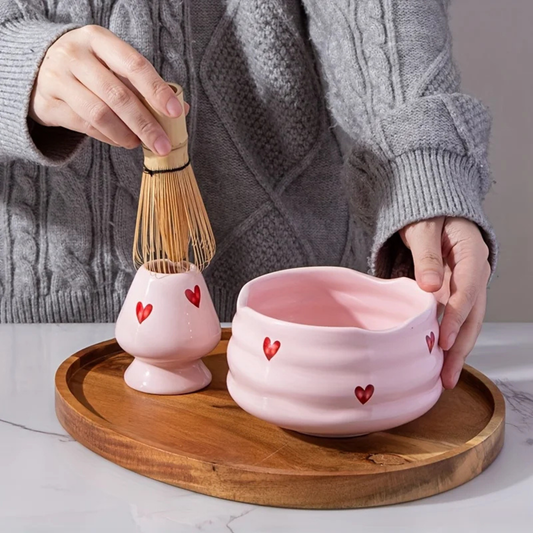 Préparation du matcha dans un bol rose à motifs cœurs, chasen en bambou en mouvement — Aoti Matcha